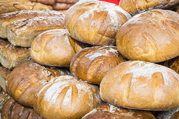 Fresh traditional loaves of wheat or rye bread on stall or in bakery