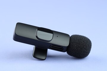 Lavalier microphone on light blue background, closeup