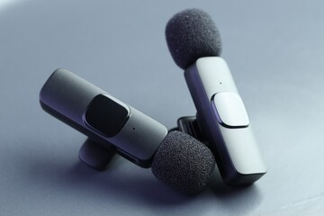 Lavalier microphones on light grey background, closeup