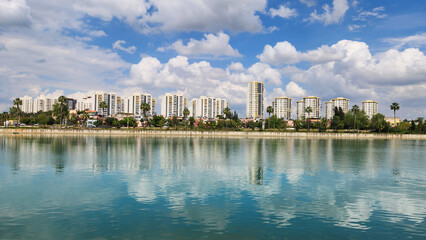 A peaceful stroll along the Seyhan River in Adana's Kisla neighborhood, surrounded by cloudy skies and the fresh bloom of April's spring beauty.