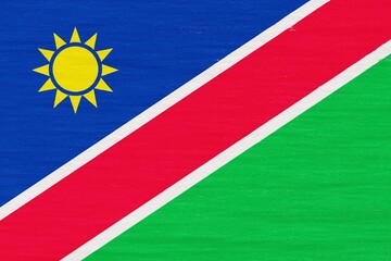 Wooden texture painted in colors of flag of Namibia. Flat view