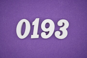 The numbers are made of white painted wood placed on a purple paper background.