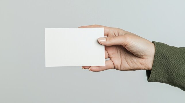 A blank business card held in a hand - Powered by Adobe