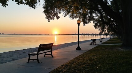 Picturesque sunrise over tranquil waters with inviting benches and pathway