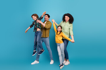 Fototapeta premium Happy young family enjoying quality time together in casual attire against a blue background with laughter and bonding moments