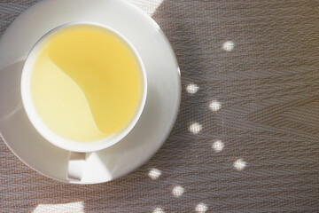 White cup and saucer with mint tea
