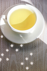White cup and saucer with mint tea
