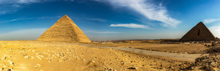 Capture the pharaonic panorama of Keops and Mycerinus pyramids in Giza, Egypt. Witness the ancient wonders of the world in this historic landscape.