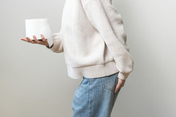 Stomach ache, sick asian young woman holding butt or crotch and holding tissue paper roll isolated...