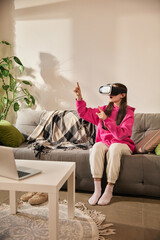 Girl gesturing in air while exploring interactive learning environment in VR headset during home...