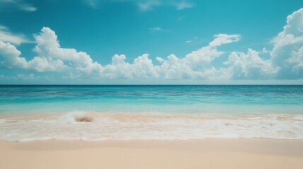 Fototapeta premium Serene beach scene with turquoise water and white sand under a bright blue sky with fluffy clouds.