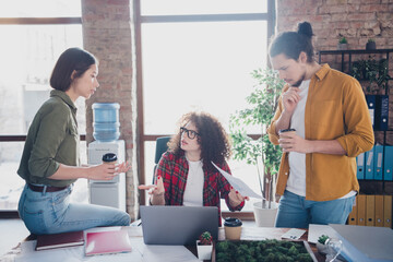 Young professionals collaborating in a modern office environment, discussing ideas and working...