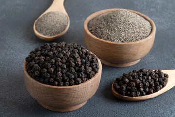 Ground black pepper with grains of black pepper on gray background
