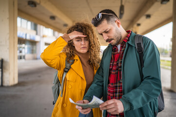 adult couple use map for navigation and explore on the train station