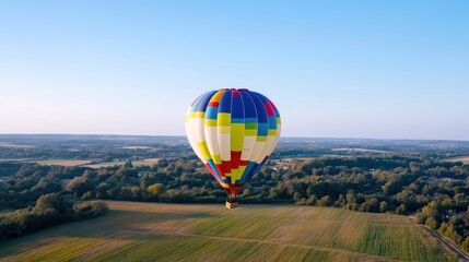 Fototapeta premium Colorful hot air balloon floats above a scenic landscape