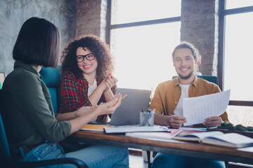 Fototapeta premium Young professionals collaborating and discussing projects in a modern workplace