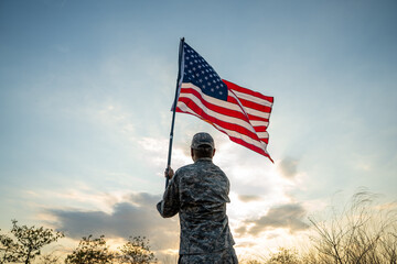 Hand Waving the Flag of the United States of America in memorial day . Us soldier holding American flag celebrating.US Army soldier celebrates holding USA flag celebrating Independence USA day