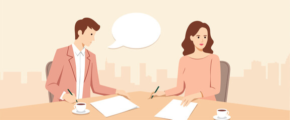 man and woman sitting at a table discussing documents and working together