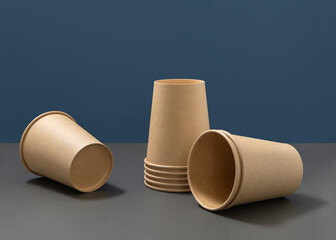 Disposable beige paper cups on a gray and blue closeup, mockup. No plastic lifestyle