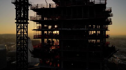 Aerial shot of a new high-rise building under construction at sunrise