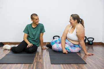 Personal trainer supporting client during fitness journey in gym