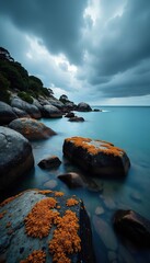 Lichen covered rocks contrasting against a dramatic stormy sky at Coles Bay, Tasmania,  rugged coastline, Lichen