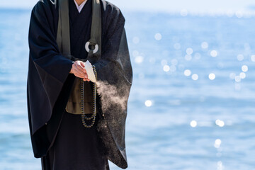 海で僧侶が供養している海洋散骨のイメージ