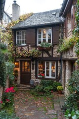 Obraz premium Charming cottage facade covered in plants, in a picturesque European village with stone paving