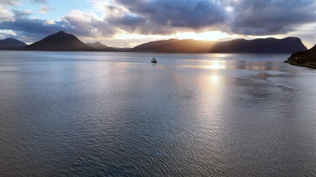 Aerial view of a car ferry crossing the Sulafjord between the islands of Hareid and Sula at sunset