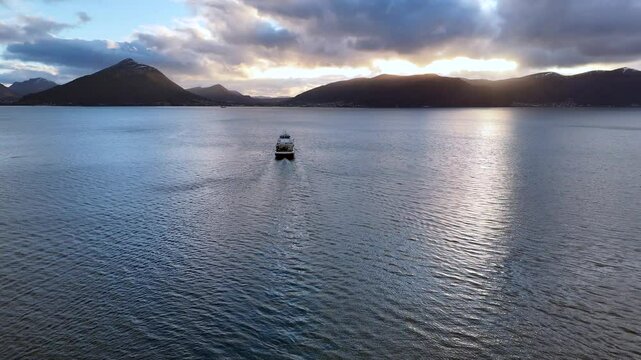 Aerial view of a car ferry crossing the Sulafjord between the islands of Hareid and Sula at sunset