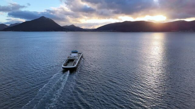 Aerial view of a car ferry crossing the Sulafjord between the islands of Hareid and Sula at sunset