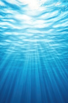 Bright sun rays penetrate tranquil blue water, creating mesmeriz