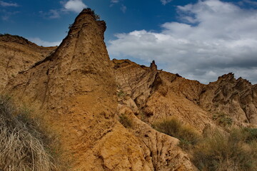 Northern Kyrgyzstan. Picturesque views of the famous Skazka Canyon, the clay mountain peaks of which have bright colors from yellow to red-brown.