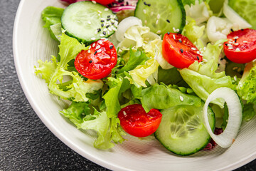 Vegetable salad tomato, cucumber, lettuce, green leaf lettuce, onion appetizer vegetable dish fresh gourmet food background rustic food top view copy space 