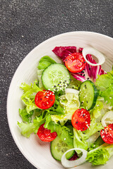 Vegetable salad tomato, cucumber, lettuce, green leaf lettuce, onion appetizer vegetable dish fresh gourmet food background rustic food top view copy space 