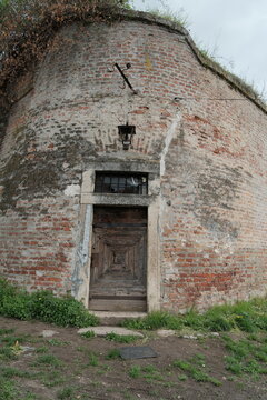 Old wooden door in a weathered brick wall of Petrovaradin Fortress in Novi Sad, Serbia. Captured in 2025, this image highlights historical detail, symmetry, and centuries-old textures.