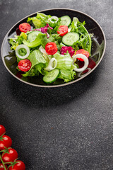 Vegetable salad tomato, cucumber, lettuce, green leaf lettuce, onion appetizer vegetable dish fresh gourmet food background rustic food top view copy space 