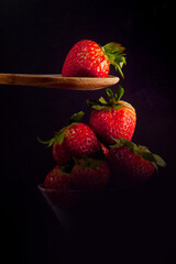 Copa de cristal con fresas y una cuchara con una fresa