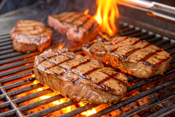 Steaks Grilling on Barbecue with Flames and Smoke