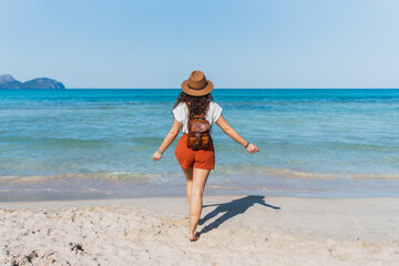 Solo Female Traveler Walking Along Mallorca Mediterranean Beach - Woman walking alone on a Mediterranean beach in Mallorca -  Concept of summer, vacation, solo travel