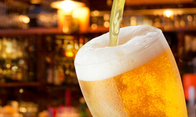 beer pouring into glass on bar background