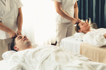 Caucasian couple enjoying relaxing anti-stress head massage and pampering facial beauty skin...