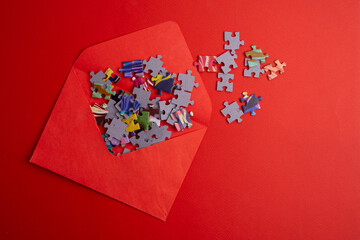 Top view of many puzzle pieces and an envelope. Background image of scattered colorful puzzle...