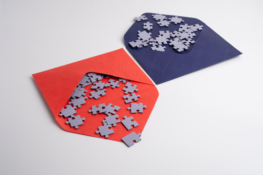 Top view of many puzzle pieces and an envelope. Background image of scattered colorful puzzle pieces. Mind games