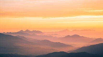 Peaceful layered mountain silhouettes at sunrise with golden sky