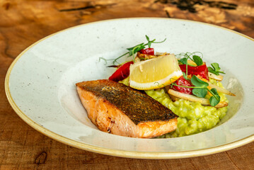 Seared salmon fillet with lemon, vegetables, and green risotto
