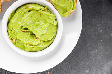 Guacamole dip avocado sauce vegetables dish organic fresh tasty gourmet food background on the table rustic food top view copy space 