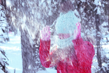 Blurred photo. Girl snowfall on the background of the forest. A child under the snow. Bad weather concept, heavy snowfall, worsening weather. blizzard, snowstorm, windstor