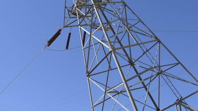 High voltage power lines are prominently displayed at Hoover Dam, capturing the intricate structure against the backdrop of a blue sky in Arizona Nevada.