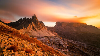 Obraz premium The iconic Tre cime di lavaredo in the Italian Dolomites at sunset in the clouds. A tourist spot in Italy in autumn colours.